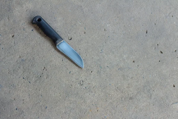 Uma faca de cozinha em um fundo cinza . — Fotografia de Stock