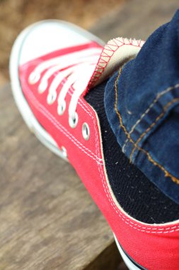 Parkta kahverengi bir arka plan üzerinde kırmızı ayakkabılar.