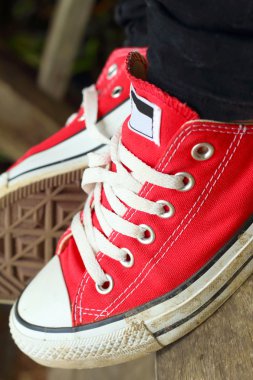 Parkta kahverengi bir arka plan üzerinde kırmızı ayakkabılar.