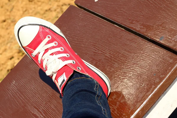Skor röd på brun bakgrund på park. — Stockfoto