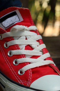 Parkta kahverengi bir arka plan üzerinde kırmızı ayakkabılar.