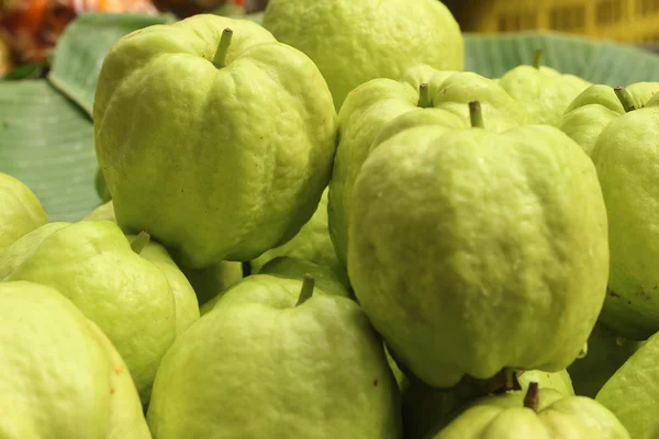 Guawa, układanie na zielonym tle na rynku. — Zdjęcie stockowe