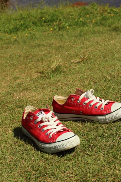Cipő piros, a zöld fű a parkban. — Stock Fotó