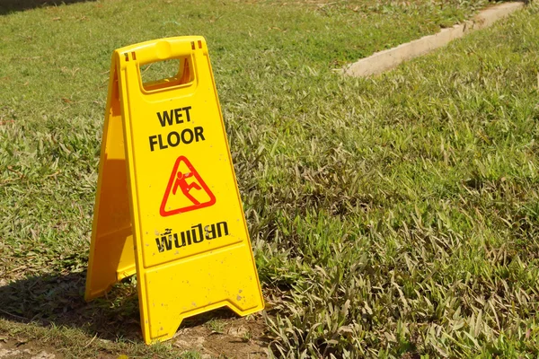 在公园的湿地板的黄色标志警告 — 图库照片