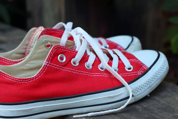 Parkta kahverengi bir arka plan üzerinde kırmızı ayakkabılar.