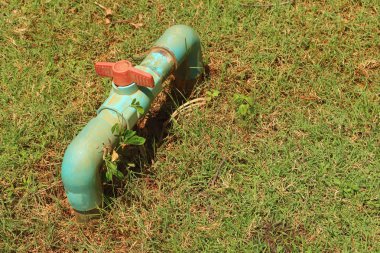 Yeşil çimenlerin üzerinde bir su boruları