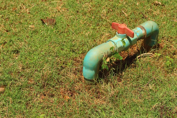 Una tubería de agua en la hierba verde — Foto de Stock