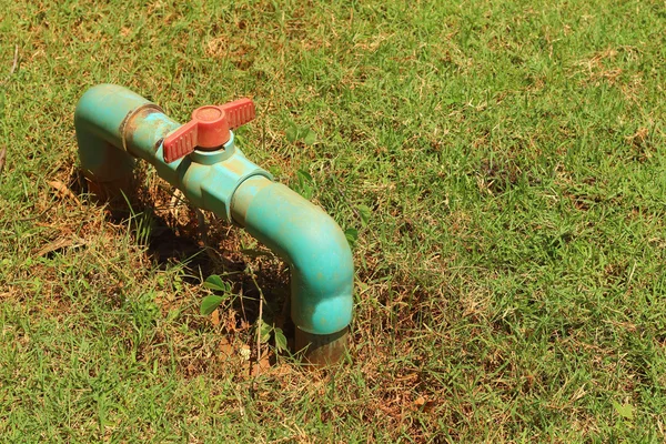 Una tubería de agua en la hierba verde — Foto de Stock