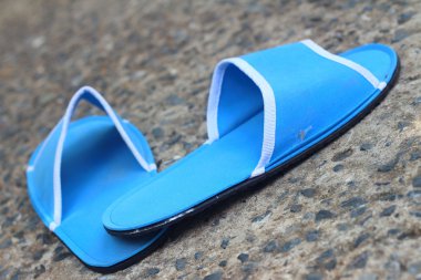 Çimento bir arka plan üzerinde mavi terlik.