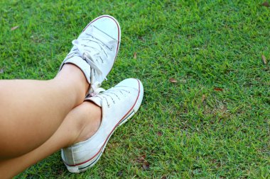 Yeşil çim zemin üzerine beyaz ayakkabı.