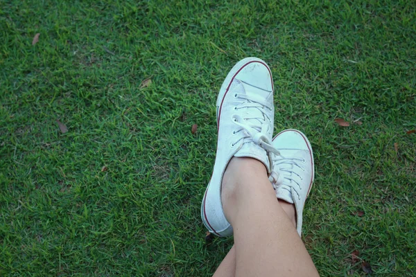 Chaussures blanches sur fond d'herbe verte . — Photo