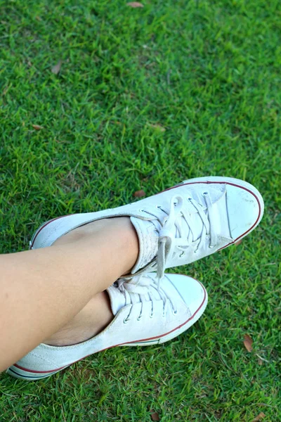 Sapatos brancos em um fundo de grama verde . — Fotografia de Stock