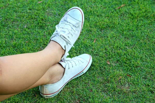 Zapatos blancos sobre un fondo de hierba verde . — Foto de Stock