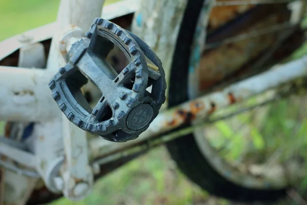 Velha roda de bicicleta em um fundo verde . — Fotografia de Stock