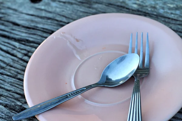 Spoon and fork on a pink plate — Stock Photo, Image