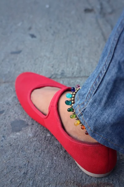 A woman wearing red shoes with jeans — Stock Photo, Image