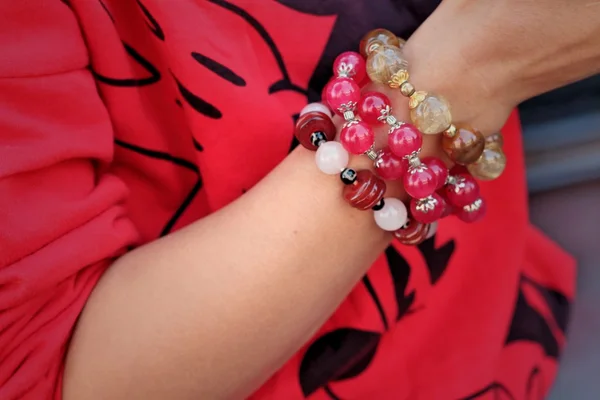 Mujer vistiendo una camisa roja y joyas pulsera . — Foto de Stock