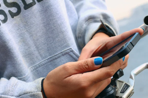 Women wearing a grey shirt is using a phone — Stock Photo, Image