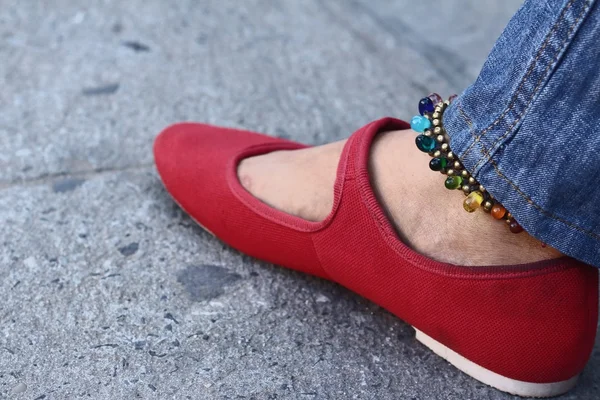 A woman wearing red shoes with jeans — Stock Photo, Image