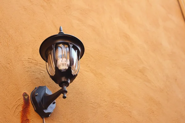 Une lampe sur un mur sur fond brun . — Photo