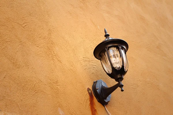 Kahverengi zemin üzerinde bir duvar lambası.