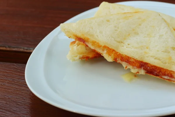 Сэндвич с ветчиной и сыром на белой тарелке . — стоковое фото