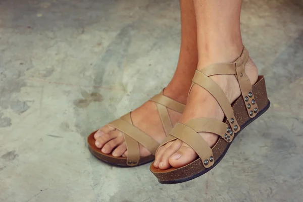 Vrouw dragen bruine schoenen permanent op een vloer van cement. — Stockfoto
