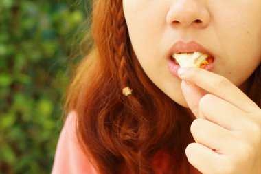 Jambon ve peynirli sandviç yemeyi kadın.