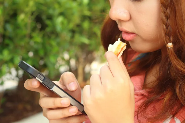 Mujer comiendo un sándwich con jamón y queso . — Foto de Stock