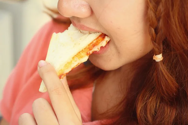 Frau isst Sandwich mit Schinken und Käse. lizenzfreie Stockfotos