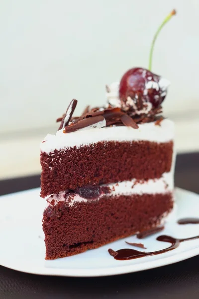 Chocolate cake met kersen op witte schotel. — Stockfoto