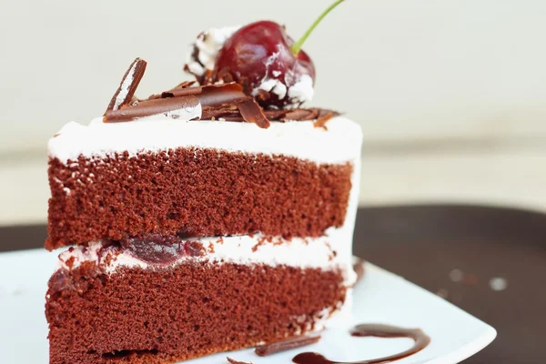 Chocolate cake met kersen op witte schotel. — Stockfoto
