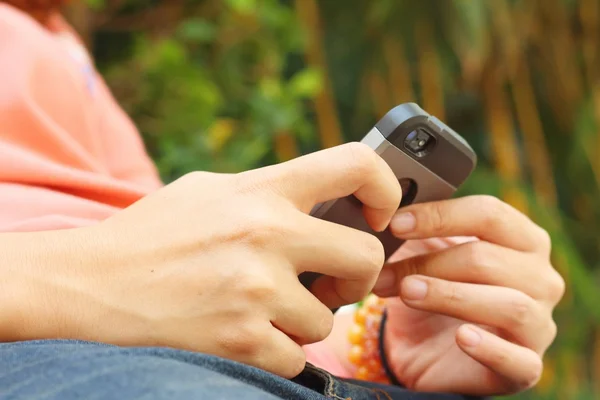 Women are using a phone at the park — Stock Photo, Image