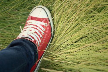 Yeşil çim bir arka plan ile kırmızı ayakkabılar.