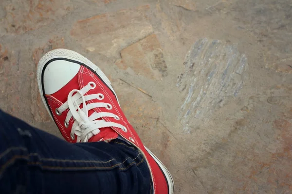 Çimento zemin üzerine kırmızı ayakkabılar.