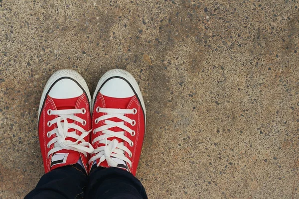 Red shoes on the background of the cement. — Stock Photo, Image