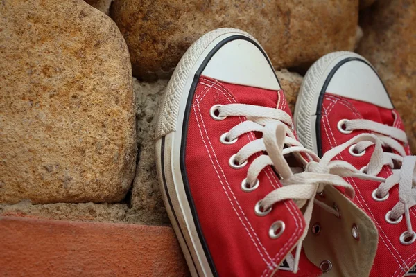 Червоне взуття на тлі коричневого каменю . — стокове фото