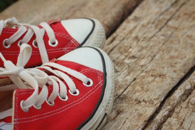 Kahverengi ahşap arka plan üzerinde kırmızı ayakkabılar