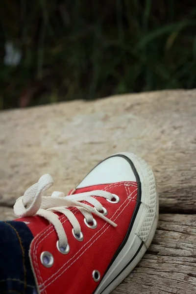 Röda skor på en bakgrund av brunt trä — Stockfoto
