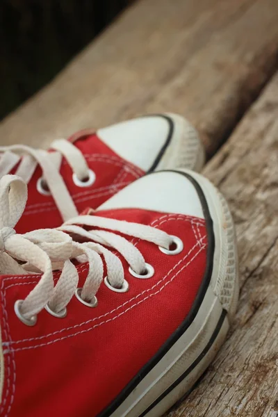 Червоне взуття на фоні коричневого дерев'яного — стокове фото