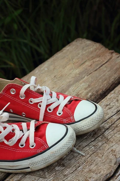 Червоне взуття на фоні коричневого дерев'яного — стокове фото