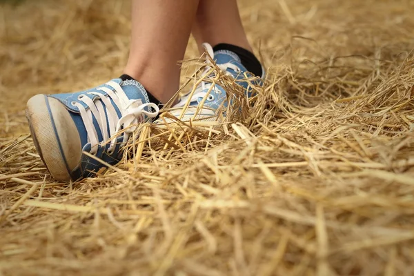 Women wearing blue shoes standing on rice straw. — Stock Photo, Image