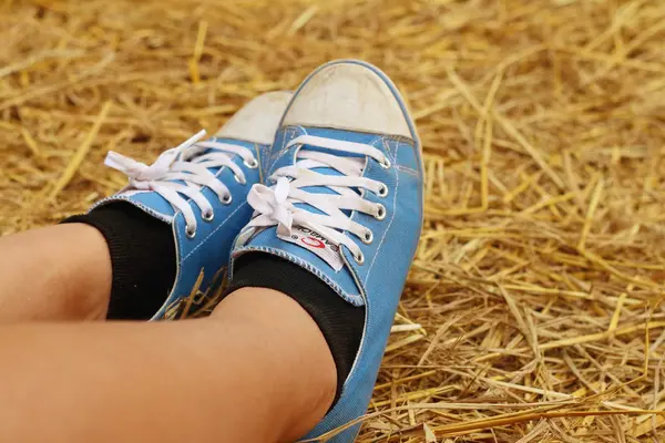 Kvinnor som bär blå skor står på ris halm. — Stockfoto