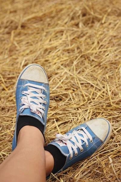 Kobiet na sobie niebieskie buty stały ryż słomy. — Zdjęcie stockowe