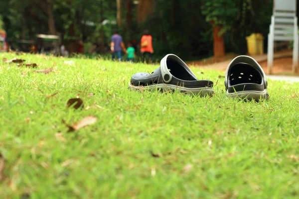 Sandalias negras en el césped — Foto de Stock