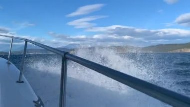 Tekne gezisi. Pasifik Okyanusu 'nun Avacha Körfezi, Kamçatka Yarımadası' nın güneydoğu kıyısı. Dalgalı mavi deniz. Güzel kayalar, dağlar, tepeler ve Kamçatka volkanları.