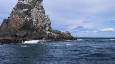 Sudan çıkan sütun şeklindeki kayalar. Avacha Körfezi boyunca seyahat et, Kamçatka Yarımadası. Tekne gezisi. Güzel mavi okyanus.