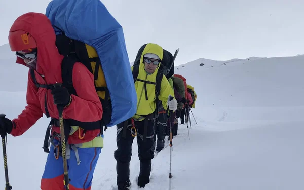 Büyük Sırt Çantaları Yürüyüş Direkleriyle Turistler Karlı Dağlarda Yürürler Dağ — Stok fotoğraf