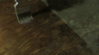 Ellerinizi koruyucu eldivenlerle kapatın. Boya işi işe yarıyor. Bir adam eski ahşap bir masayı cilalıyor. Mavi sivilceli ve sarı kenarlı beyaz eldivenler..