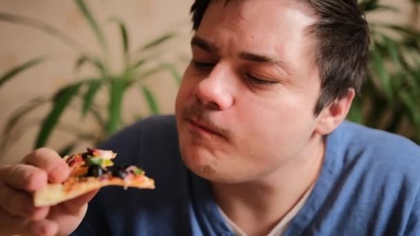 Lätt Rakad Ung Man Äter Vegetarisk Pizza Med Svamp Tomater — Stockvideo